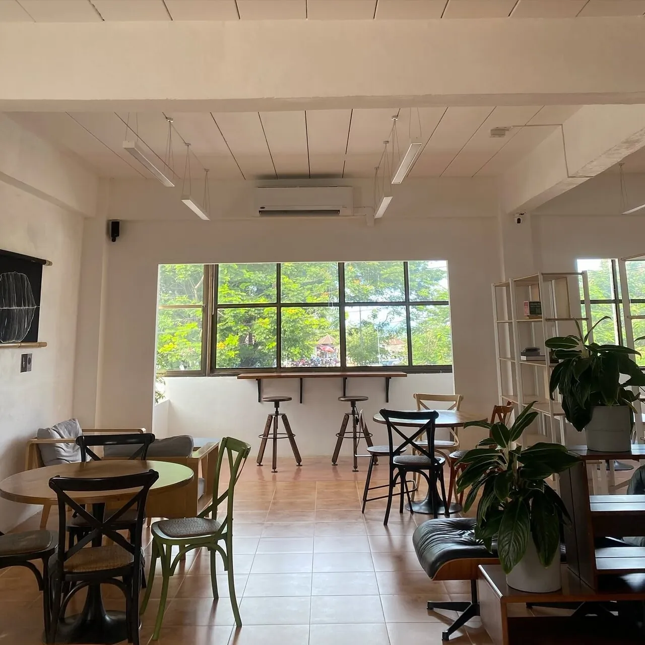 Window seating, round tables, and bar stools overlooking the street