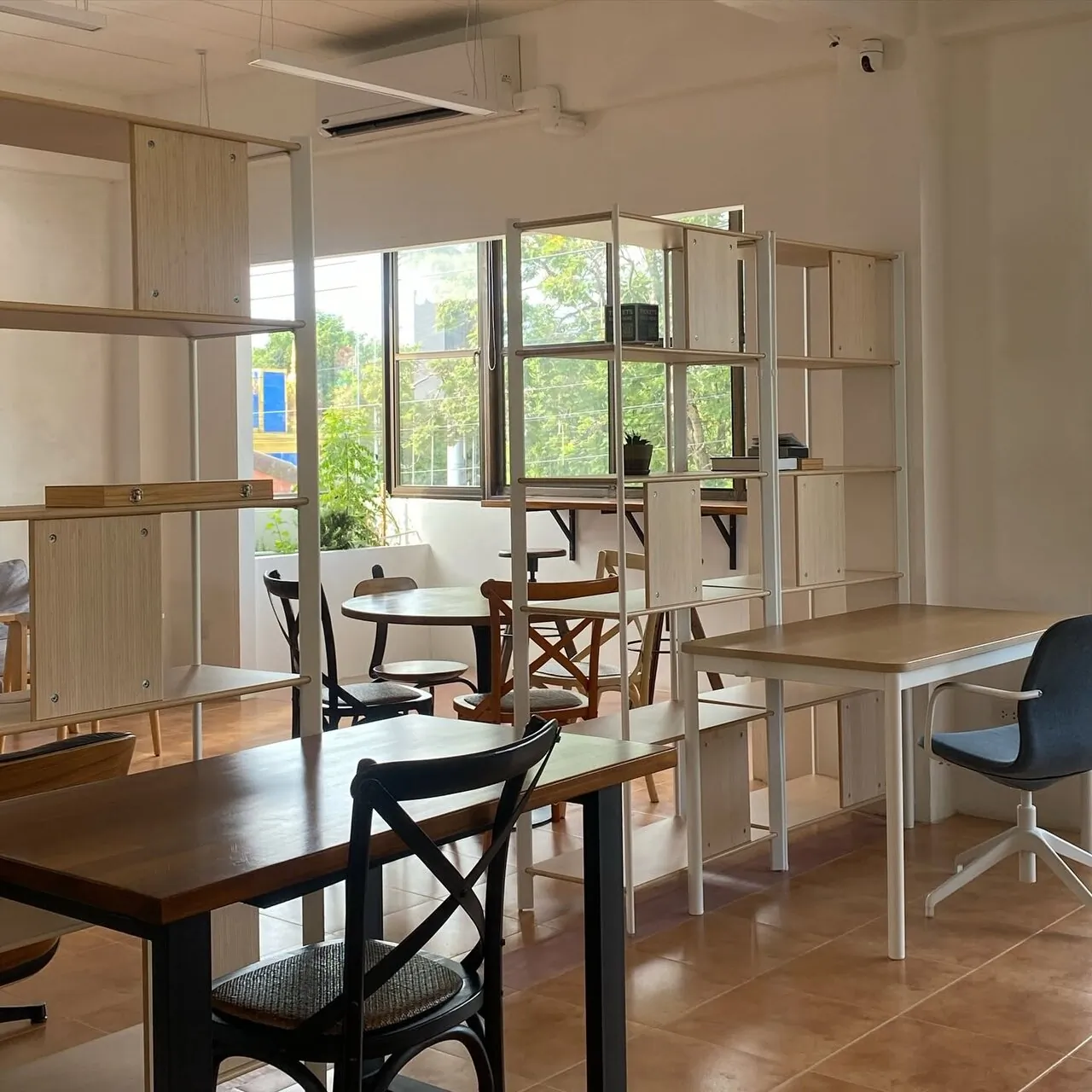 Work tables separated by open shelving near the windows